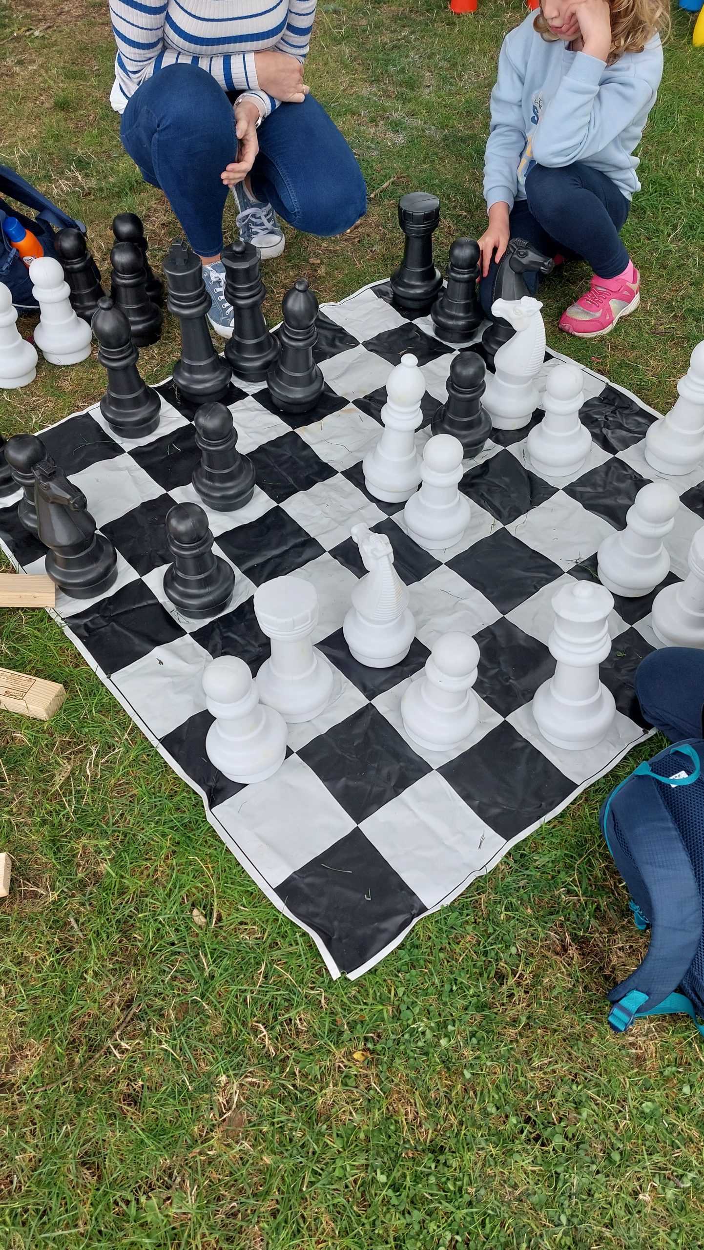 a giant chess game being played by adults and children