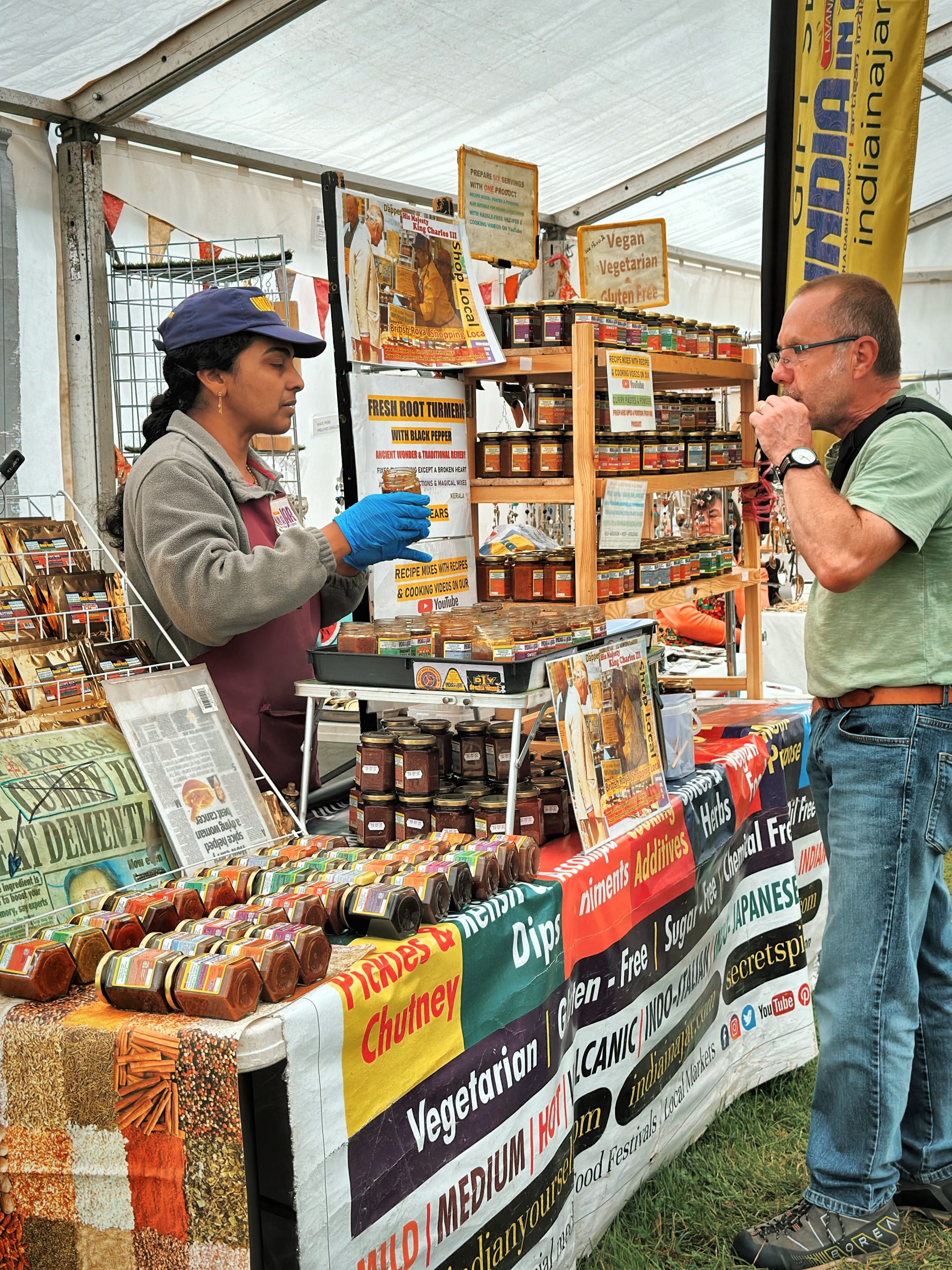 a trader in the Artisan Marquee discussing their produce with a customer