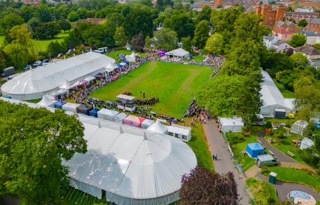 Drone view of Vivary Park set up for Taunton Flower Show. The picture is taken above the competition marquee and shows the arena, the the Rock choir performing, crowds watching and a good view of the Floral Marquee.